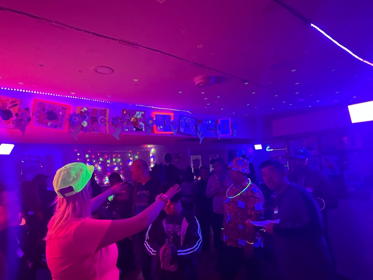 Catching Stars participants celebrating together in a Glow Dance Night crowd.
