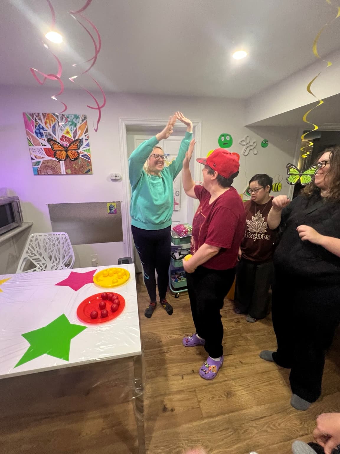 Catching Stars Social Club participants sharing an energetic high-five during an inclusive adult program.