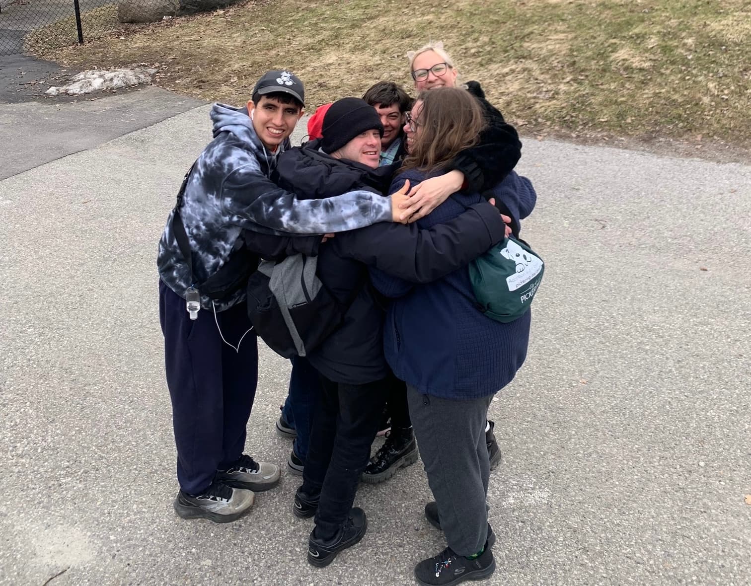 Catching Stars participants sharing a joyful group hug during a community outing.
